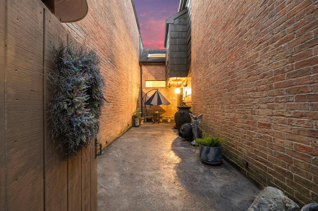 The brick-lined exterior entryway exudes charm, creating a delightful transition to the outdoor patio, perfect for adding a unique touch to welcoming guests.