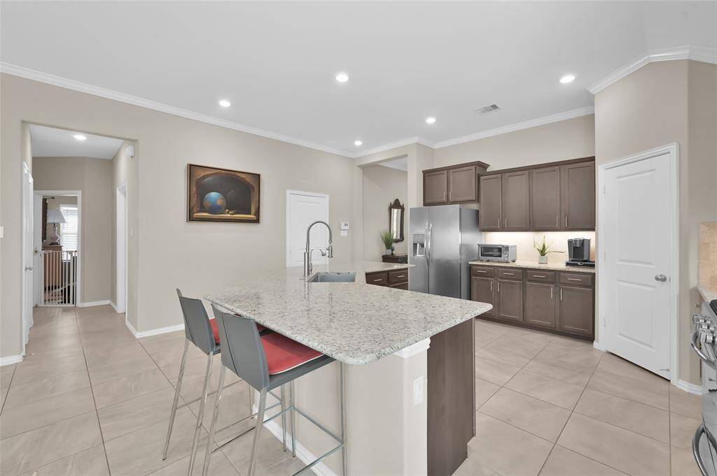 Ample seating around the island.  The hallway pictured leads to the laundry room, 2 secondary bedrooms, a full bathroom and an open 'flex' space that could easily be enclosed for a 4th bedroom.