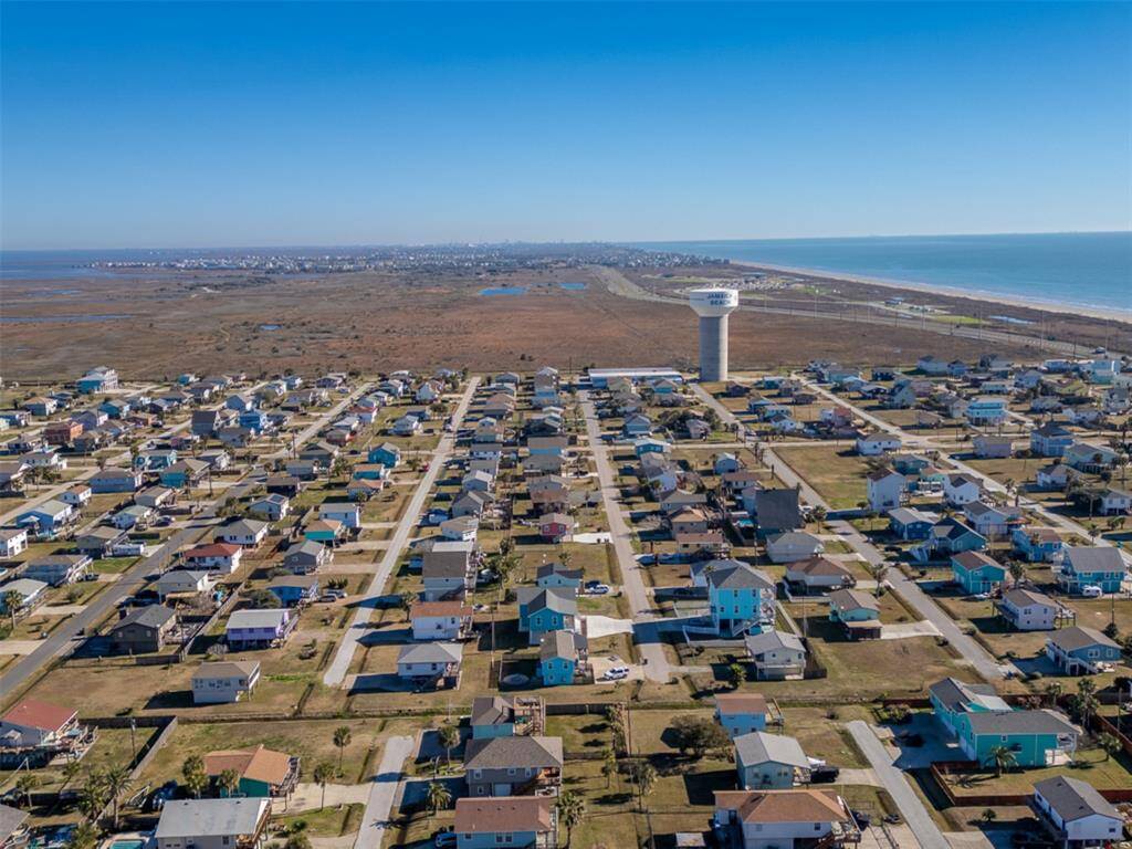 This aerial photo showcases a coastal neighborhood with neatly aligned homes and proximity to  scenic Jamaica Beach, offering a serene and picturesque living environment.