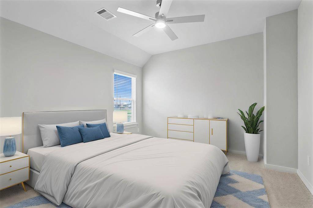 Secondary bedroom features plush carpet, custom paint, ceiling fan with lighting, ample closet space, and a large window with privacy blinds.