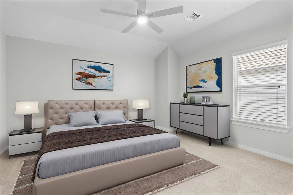 Secondary bedroom features plush carpet, custom paint, ceiling fan with lighting, ample closet space, and a large window with privacy blinds.