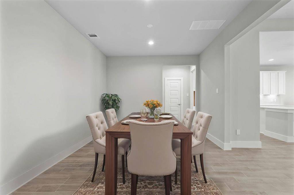 Make memories gathered around the table with your family and friends! This dining room features high ceilings, custom paint, recessed lighting, and gorgeous wood look tile flooring.