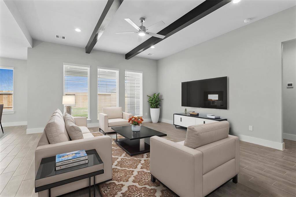 Gather the family and guests together in your lovely family room! Featuring the beautiful wood beams, ceiling fan, recessed lighting, large windows with blinds, custom paint, and beautiful wood-look tile floors.
