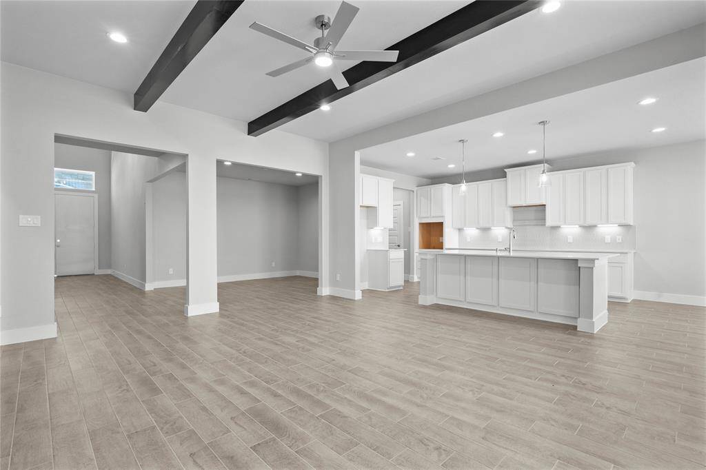 Another view taken from the Family Room looking towards the kitchen, breakfast nook and dining areas. The wood beams really make a statement in this grand living space!