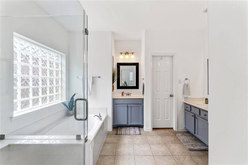 This bright, airy bedroom features high ceilings, a ceiling fan, and ample natural light.