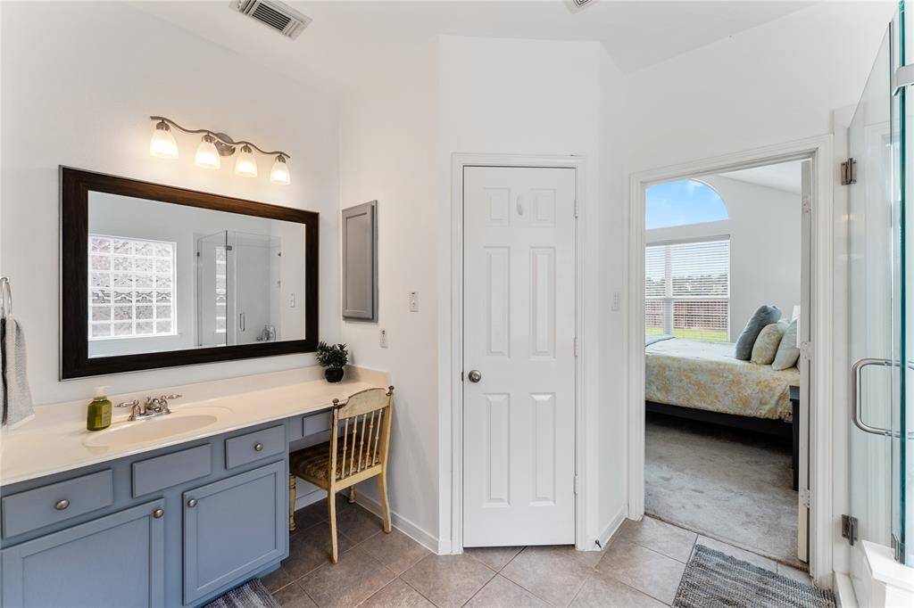 Primary bathroom features a seamless glass-enclosed shower, a large soaking tub, and a glass block window for privacy and natural light.