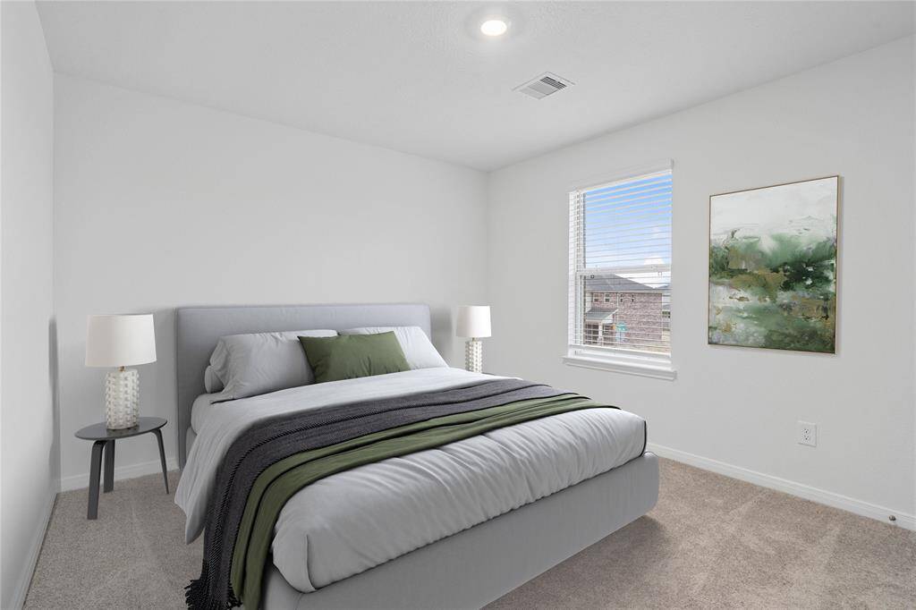 Secondary bedroom features plush carpet, neutral paint, lighting, large window with privacy blinds and a walk-in closet.