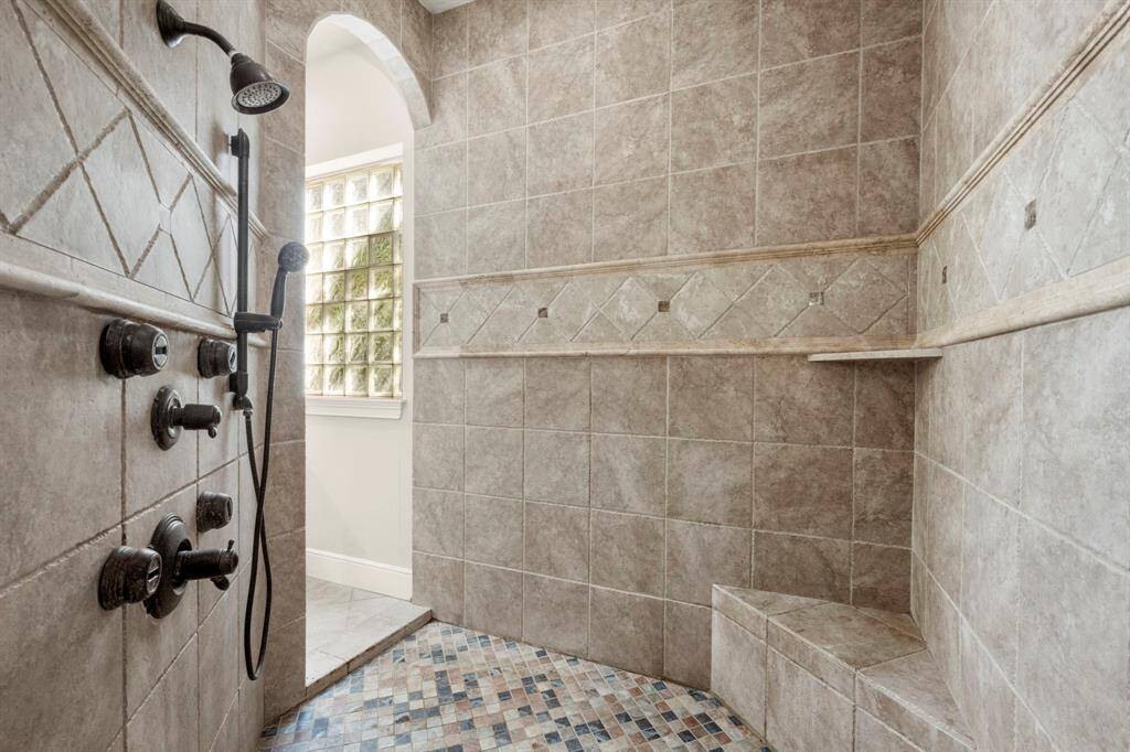 Shower walk-in from both sides and includes bench seat, body sprayers, hand-held sprayer and shower head.