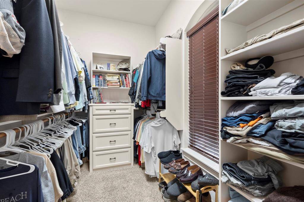 Primary closet #1 - built-in dresser, shelving and a window for great lighting.