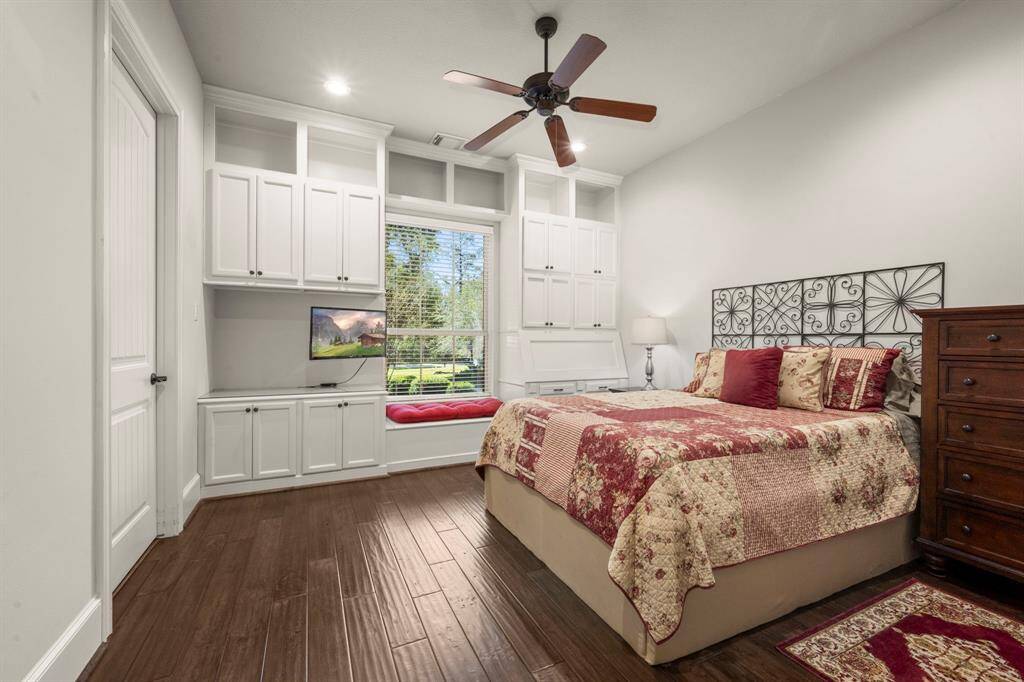 Bedroom 2 - Downstairs bedroom with ensuite bath, large walk-in closet, wood flooring, ceiling fan, storage cabinets and drop-open desk.
