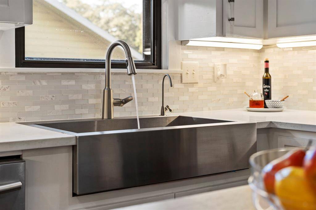 Deep basin farmhouse sink with pull-down faucet and reverse osmosis water filtration system.