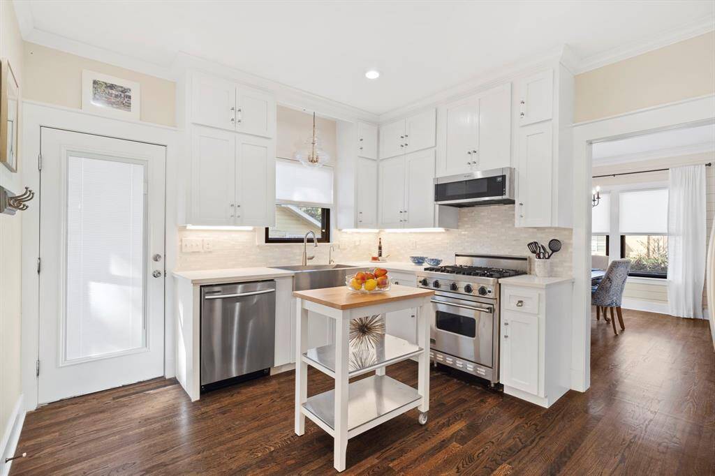 The kitchen is open to the dining room and also features a side door to the driveway and a walk-in utility closet with wash machine and dryer hookup and cleaning supply storage.