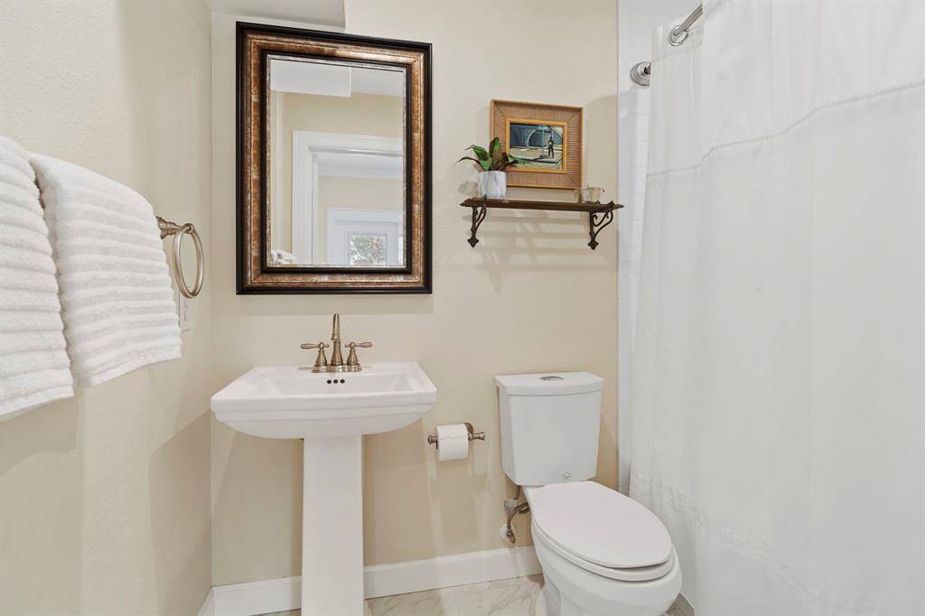 En suite primary bathroom features a porcelain pedestal sink and shower/tub combo.