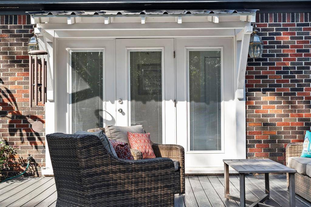 Energy-efficient insulated glass French doors with sidelights. Corrugated metal roof protects back entrance to the home.