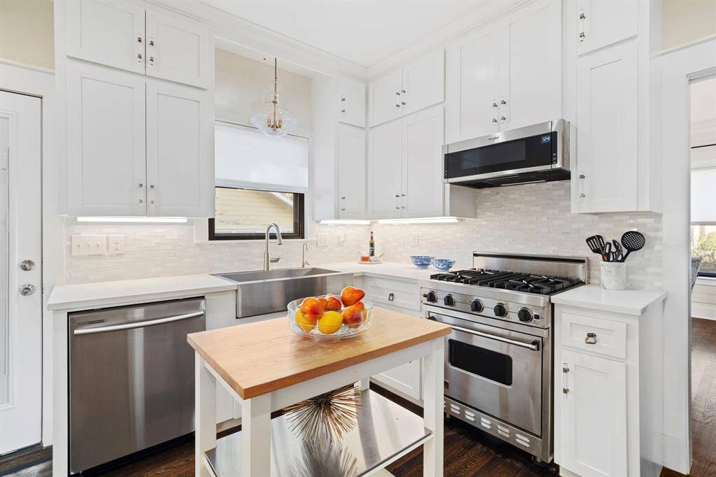 Updated, modern kitchen with white quartz countertops, custom cabinetry and stainless steel appliances.