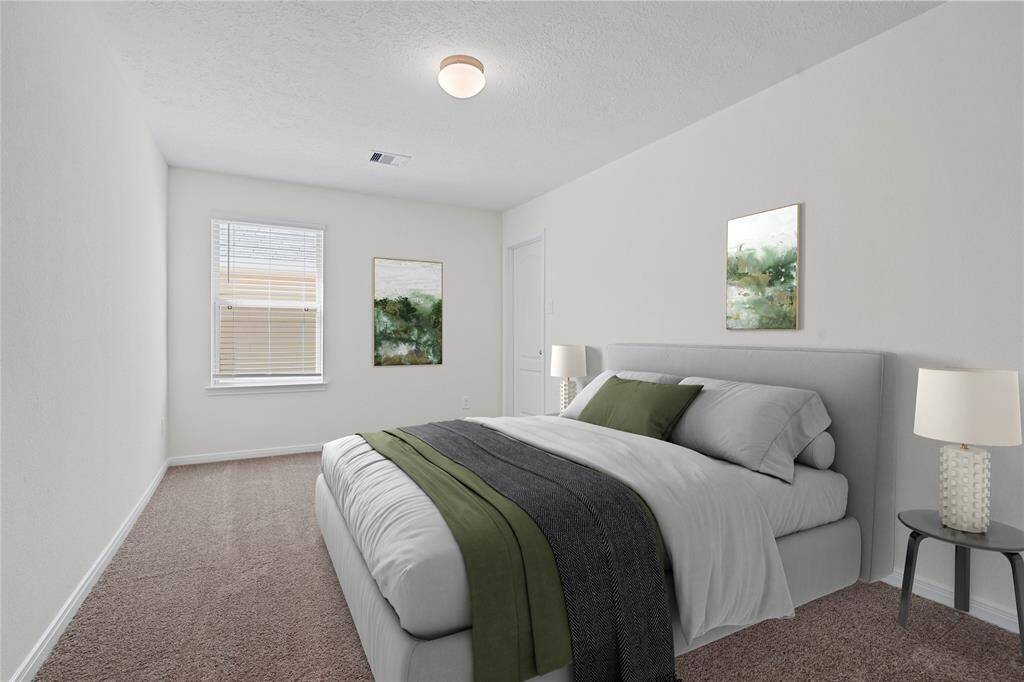 This secondary bedroom features high ceilings, custom paint, plush carpet, and a large window with privacy blinds!