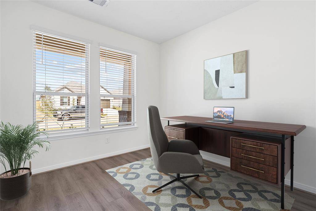 The front den pictured here as a home office features plenty of natural light with large windows and privacy blinds, lighting, and gorgeous vinyl plank flooring!