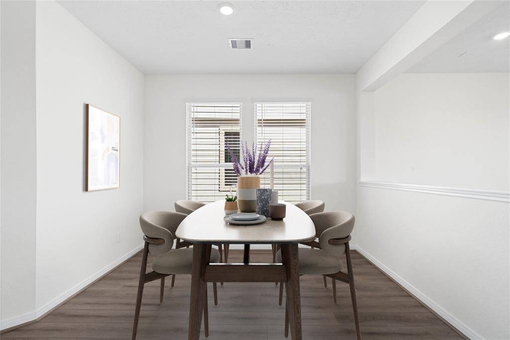 This formal dining area features high ceilings, recessed lighting, large windows with privacy blinds, and vinyl plank flooring!