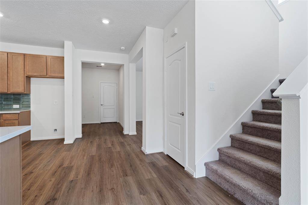This view features the staircase leading to the second floor loft, primary and secondary bedrooms, and primary and secondary bathrooms.