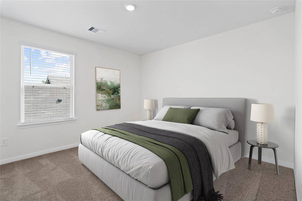 Secondary bedroom features plush carpet, neutral paint, recessed lighting, large window with privacy blinds and a walk-in closet.
