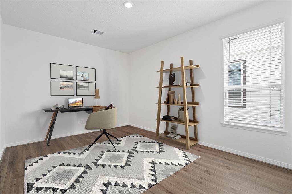 Quietly nestled in front of the home is the handsome den, pictured here as a home office! Featuring gorgeous vinyl plank flooring, high ceilings, large window with privacy blinds and custom paint!