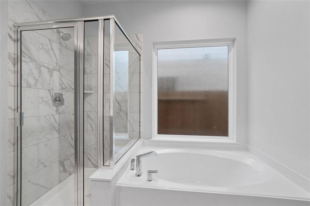 Additional feature of the primary bathroom is this oversized garden tub and walk-in shower with tile surround.