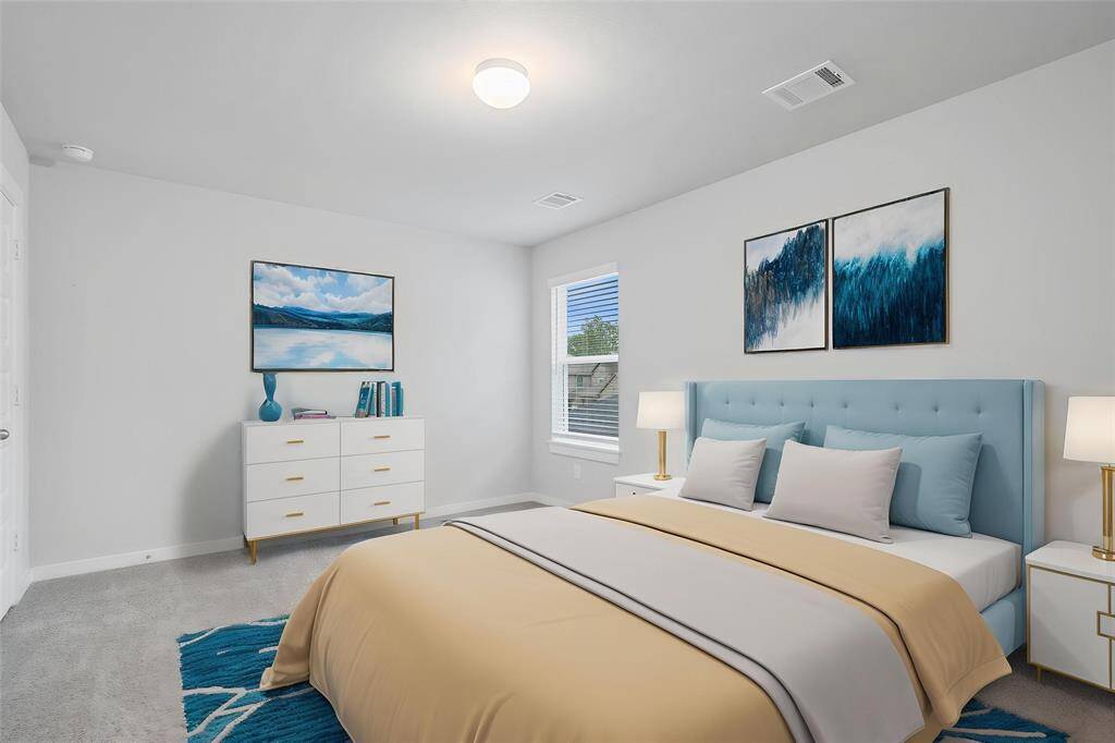 Secondary bedroom features plush carpet, custom paint, high ceiling, lighting, ample closet space, and large window with privacy blinds.