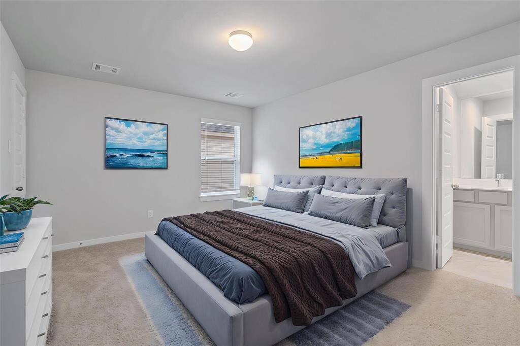 Secondary bedroom features plush carpet, custom paint, high ceilings, lighting, large window with privacy blinds, and private access to a secondary bathroom.