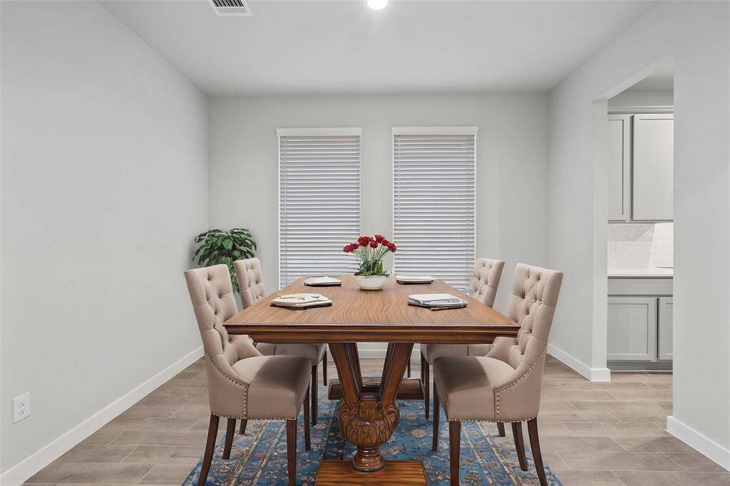 You and your guests will certainly dine in style in this amazing formal dining room! Featuring large windows with privacy blinds, neutral paint, high ceilings, and wood look tile flooring! Perfect space to entertain family and friends!