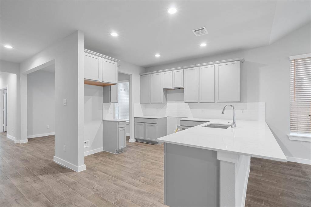 This kitchen is by far any chef’s dream! This spacious kitchen features high ceilings, stained wood cabinets, quartz countertops, modern tile backsplash, recessed lighting, extended counter space for breakfast bar, and pantry all overlooking your huge family room.