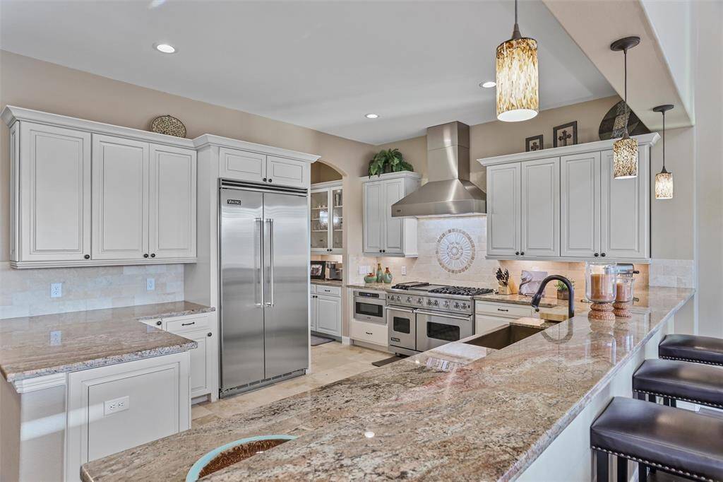 Experience culinary bliss in this chef-inspired kitchen featuring a sleek breakfast bar.