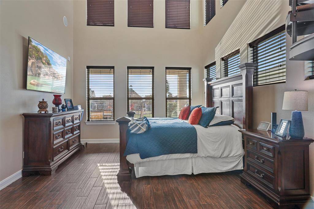 The primary bedroom boasts abundant natural light and soaring ceilings.