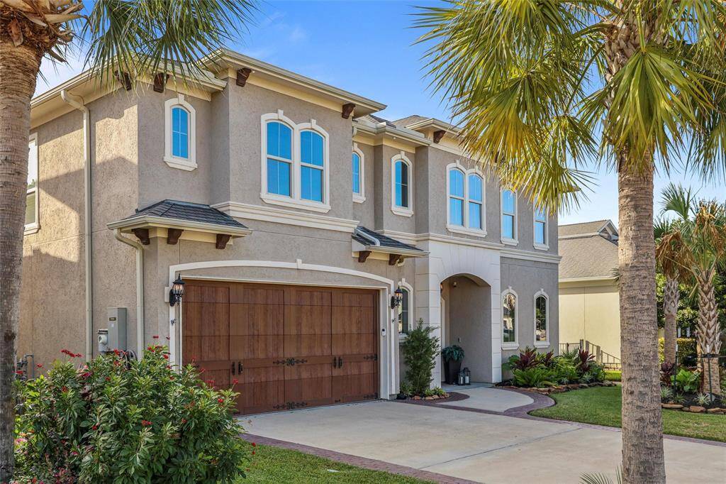 Stylish garage doors lead to a spacious two-car garage.