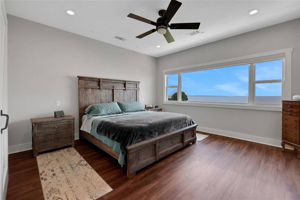 The primary suite is on one side of the home and the windows capture that lake view