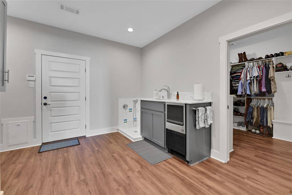 In the laundry room there is a free standing industrial ice machine, sink and dog shower