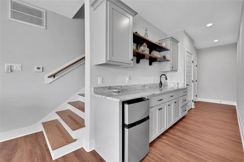 The lower living area has kitchenette area, storage under the stairs under the stairs with custom built ins and at the end is a closet framed for elevator install