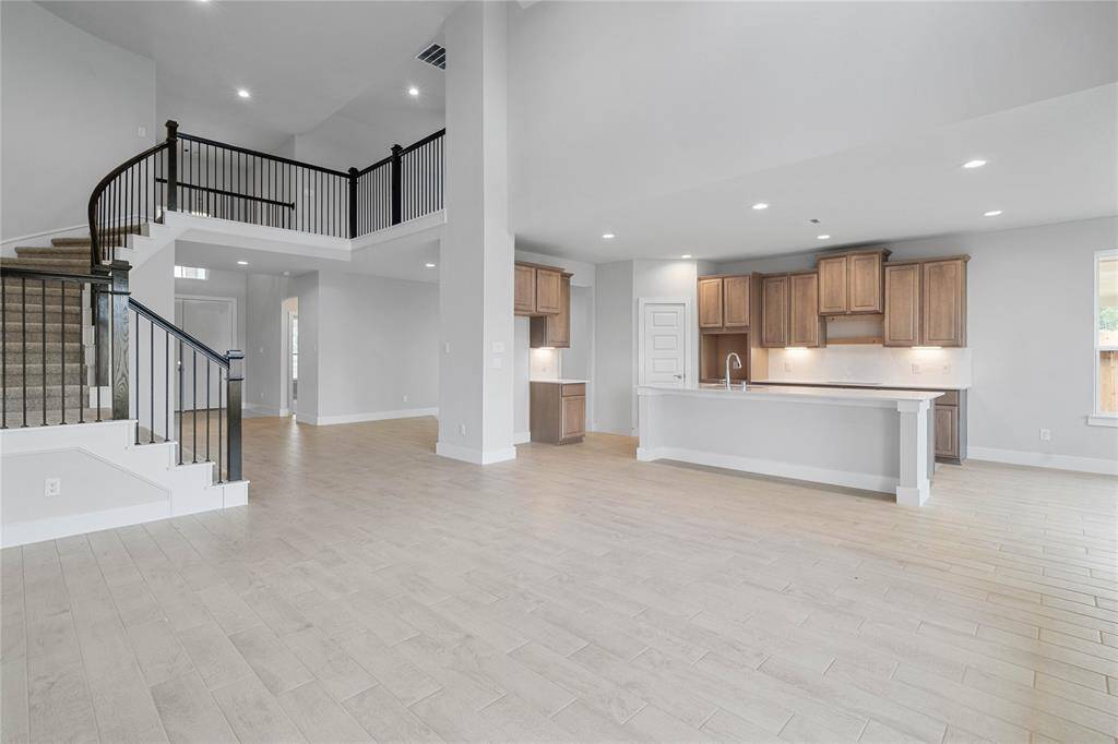 This open concept living space is absolutely stunning and it features the family room, kitchen, breakfast and dining areas. The grand staircase with wrought iron railing leads you to the second floor.
