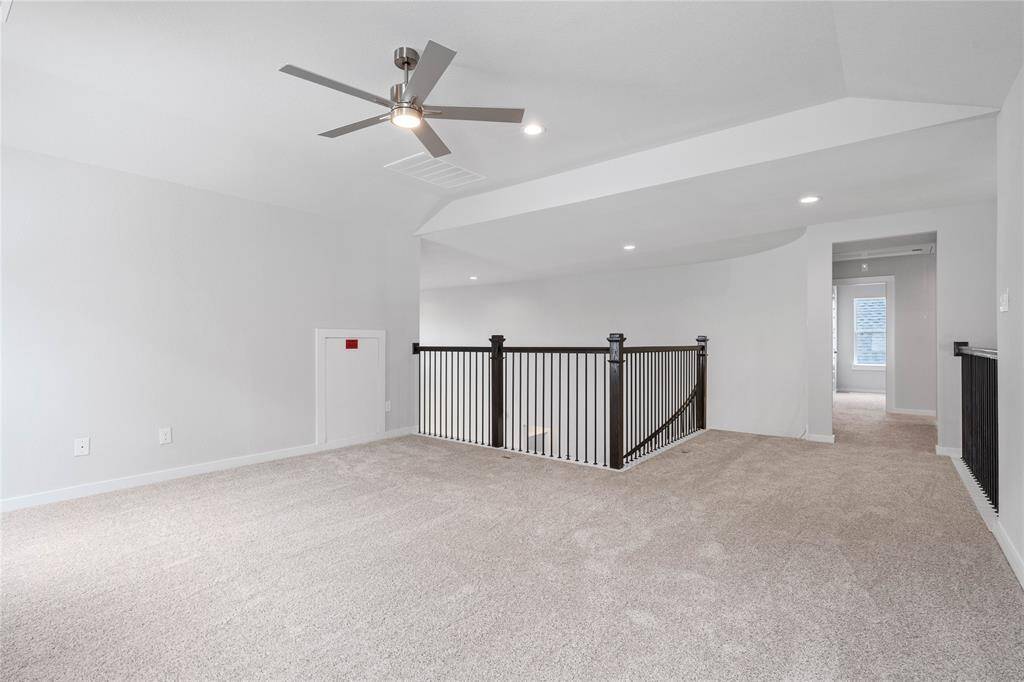 Additional view taken from the Game Room looking out to hallway and staircase. The staircase railing is a beautiful feature of this home!