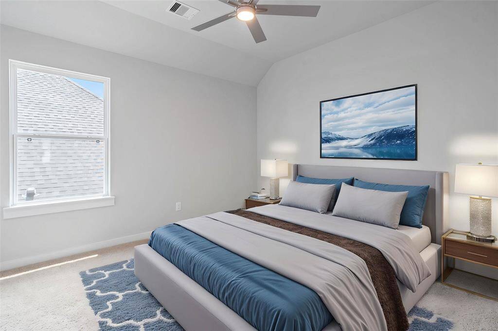 Secondary bedroom features plush carpet, custom paint, ceiling fan with lighting, closet space, and large windows!