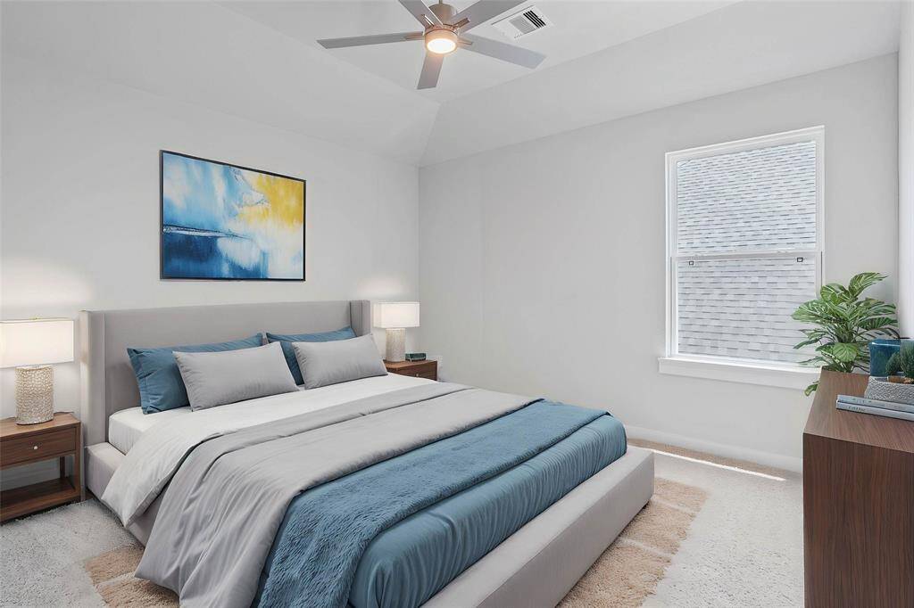 Secondary bedroom features plush carpet, custom paint, ceiling fan with lighting, closet space, and large windows!