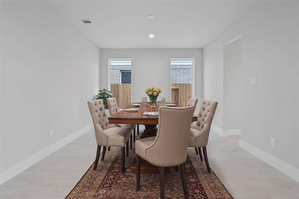 Make memories gathered around the table with your family and friends! This dining room features high ceilings, recessed lighting, custom paint, large windows, and gorgeous wood look tile flooring.