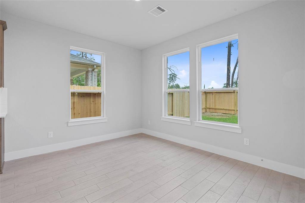 This lovely breakfast area is perfect for starting the day out on the right foot! This space showcases custom paint, high ceilings, recessed lighting, large windows adding to the ample natural light in the kitchen, and wood look tile flooring!