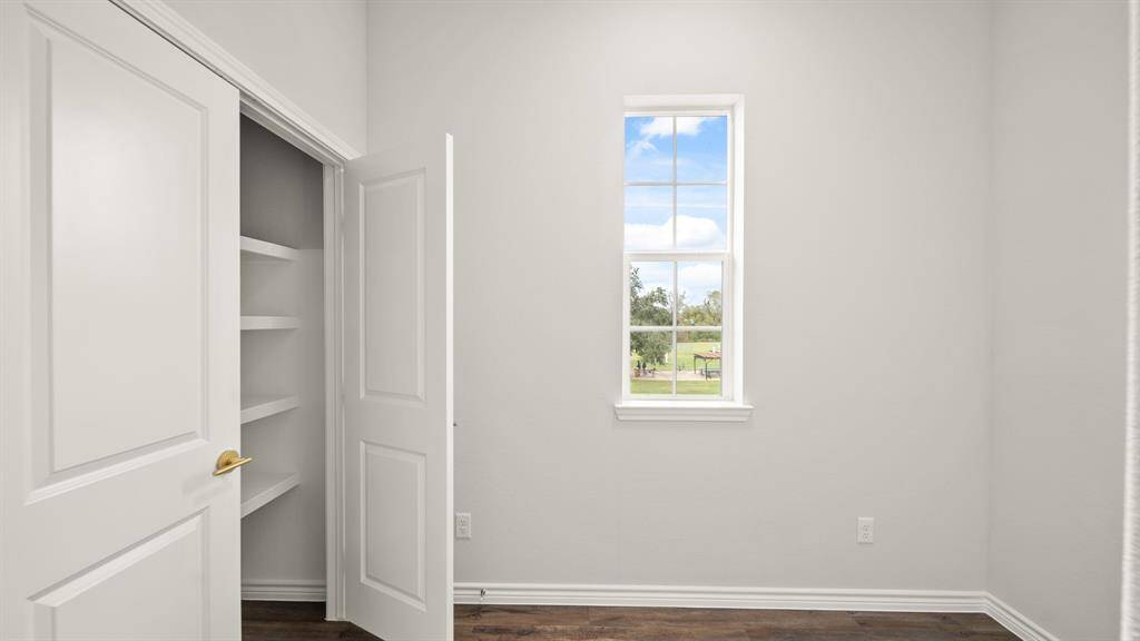 This room features natural light, a closet with shelving, offering a cozy and functional space.
