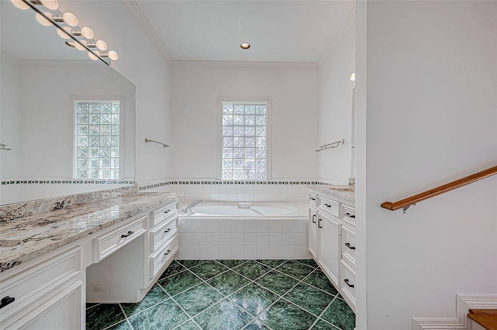 luxurious master bath with dual sinks, a whirlpool tub, a separate shower, and a spacious walk-in closet.