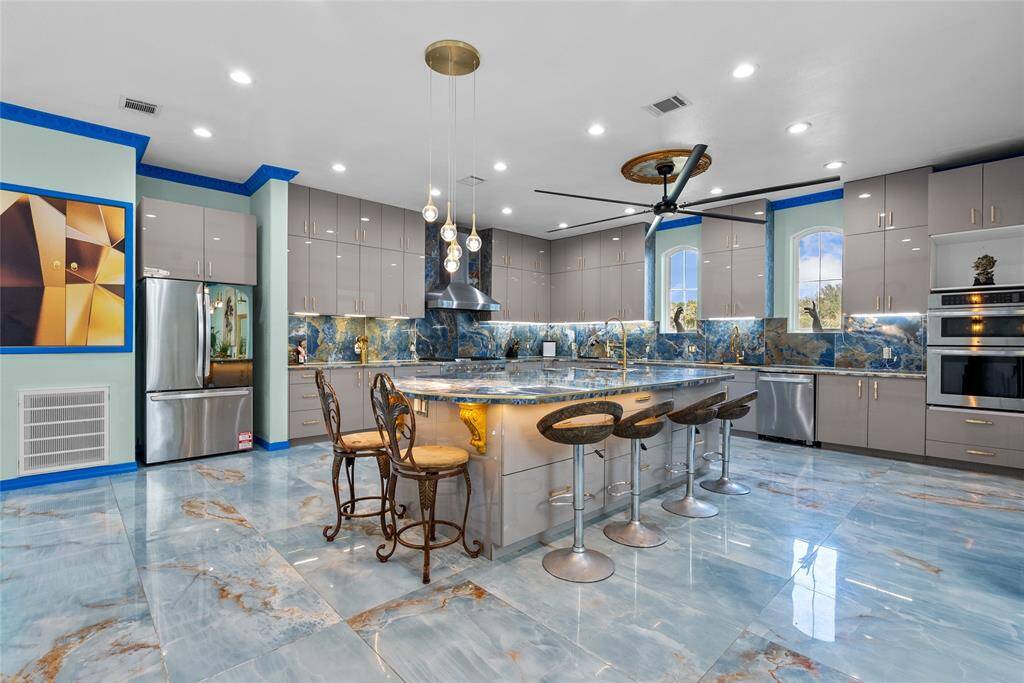 Large center island, modern appliances, ceiling fans, and special lighting , can comfortably accommodate guest and serving requirements as well.