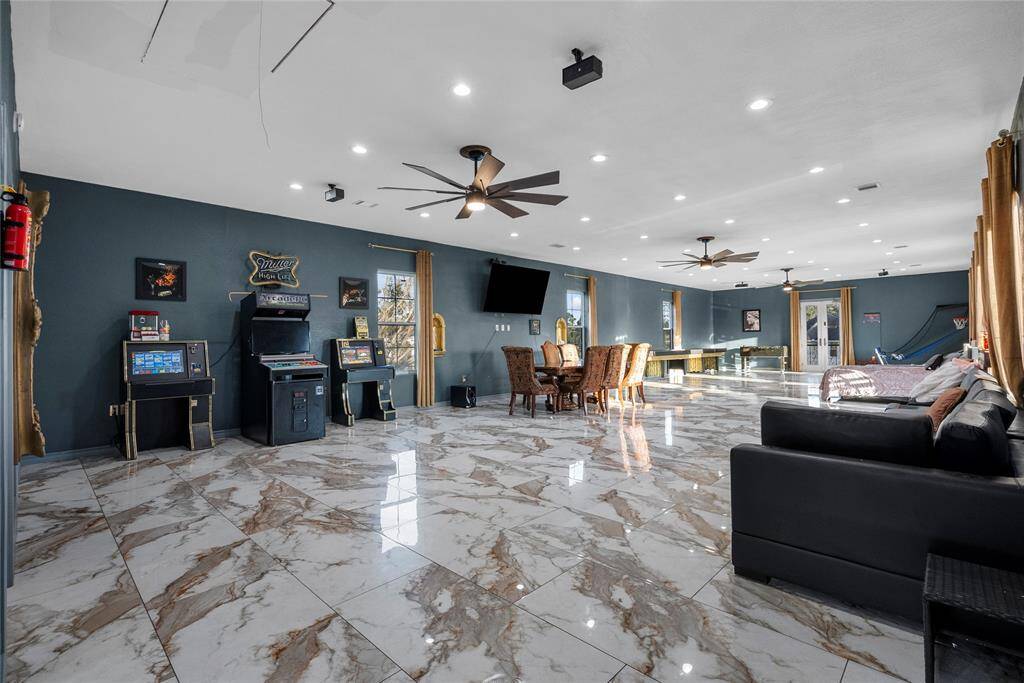 Massive game room or media room, with porcelain floors, bathroom and shower, ceiling fans