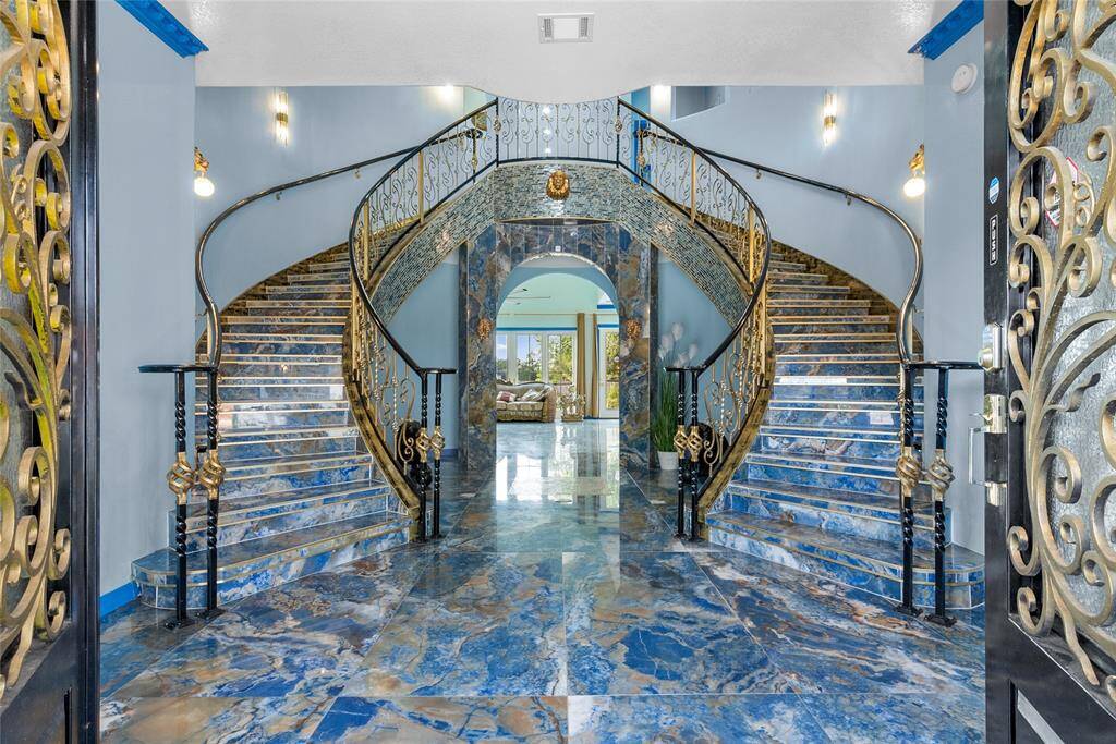 Grand entry,with ornate dual staircases, illuminating as you progress , porcelain floors