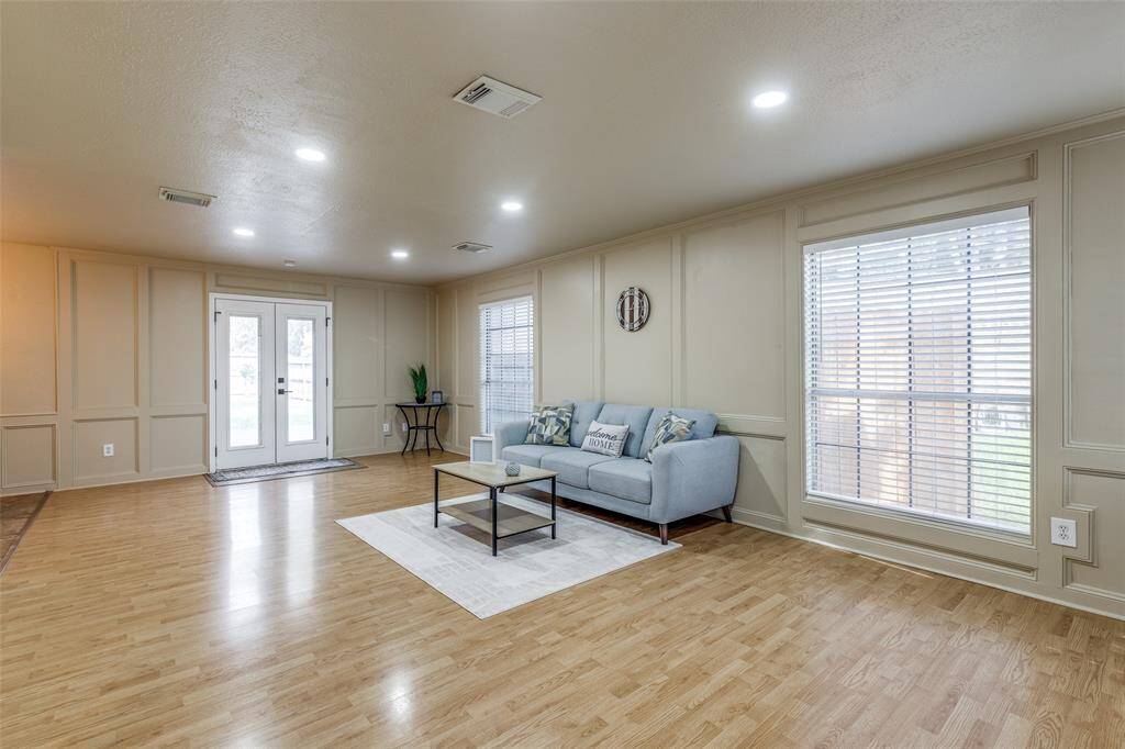 To the right, this spacious living room/dining room blend offers plenty of natural light and dimmable recessed lighting, creating a warm inviting ambiance. The French doors offer a seamless transition between indoor comfort and outdoor serenity.