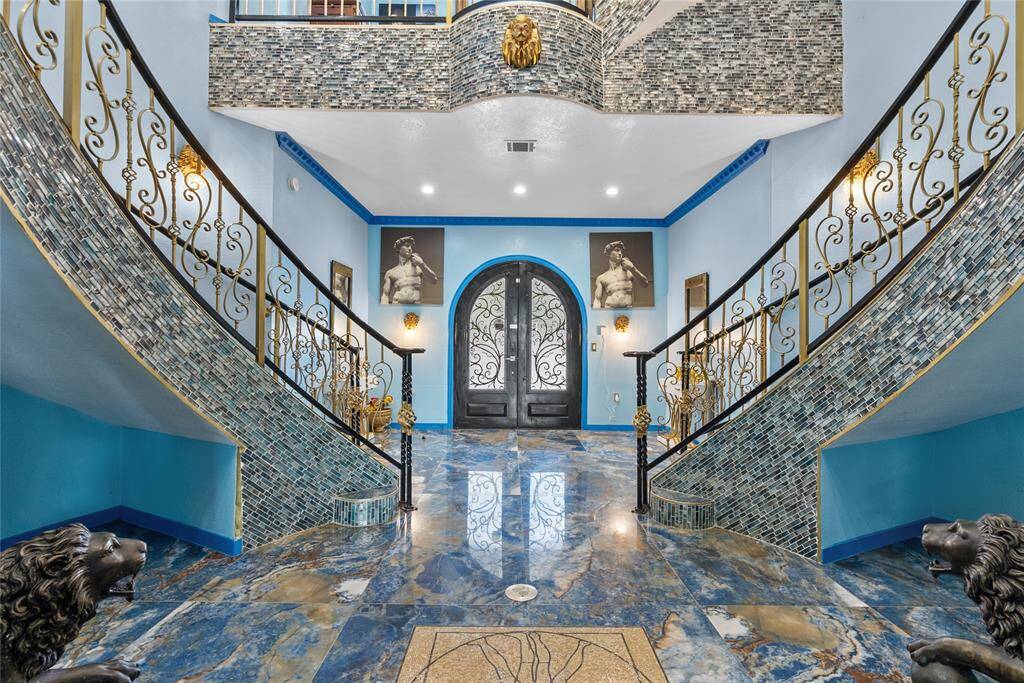 Entry, with dual staircases, a open foyer, porcelain floors, mosaic like tile trims the staircases.