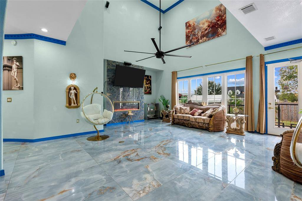 Living area features ceiling fans, electric fireplace, and open concept to back yard.